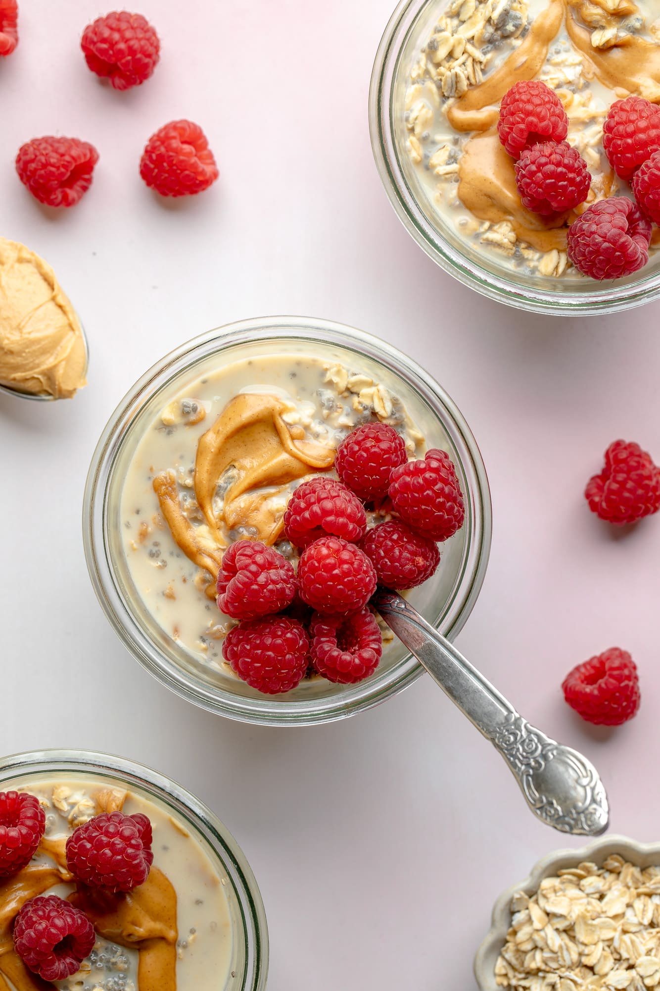 View on top of peanut butter jars during the night topped with fresh raspberries.