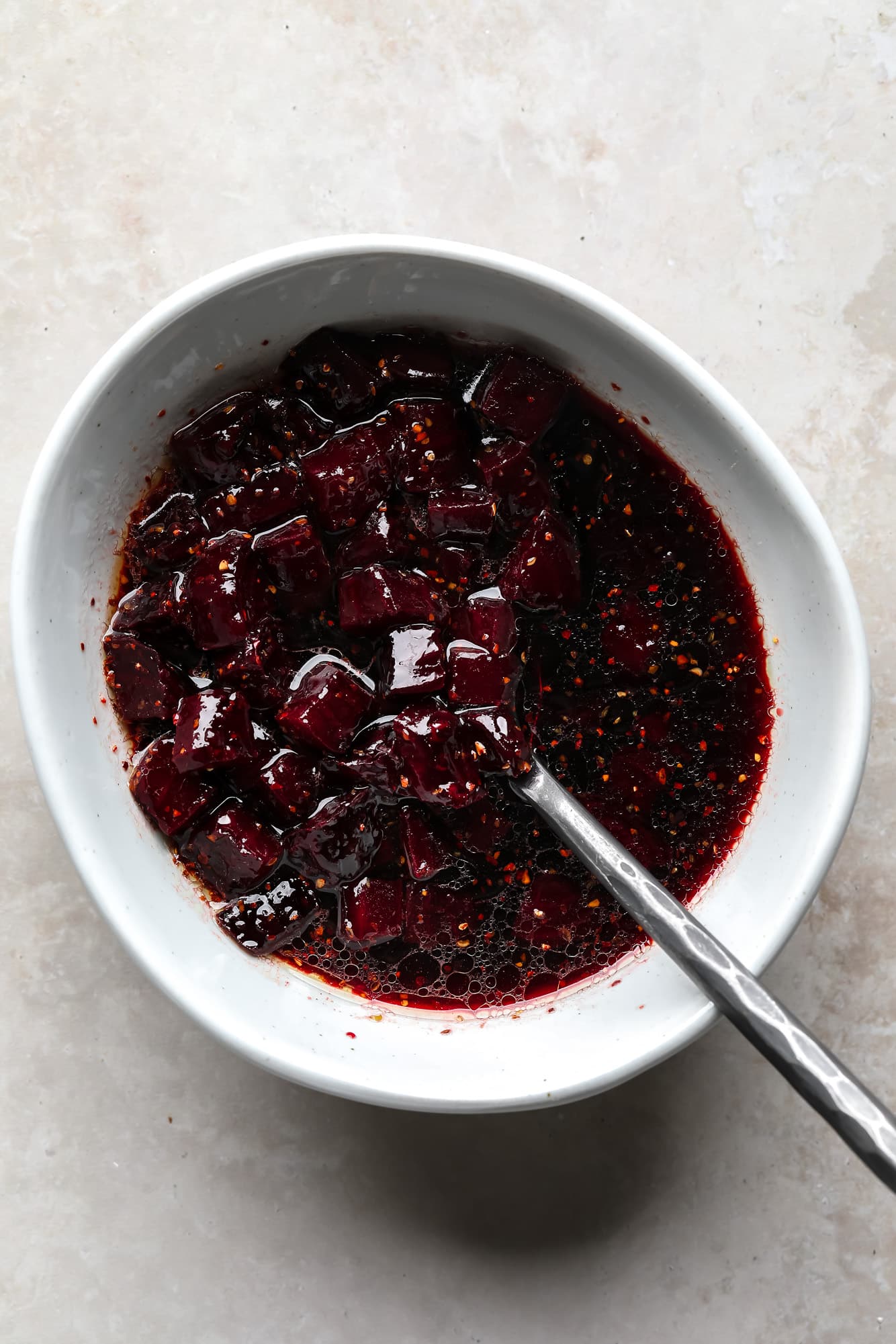 Roasts roasted in a dark red marinade in a white bowl.