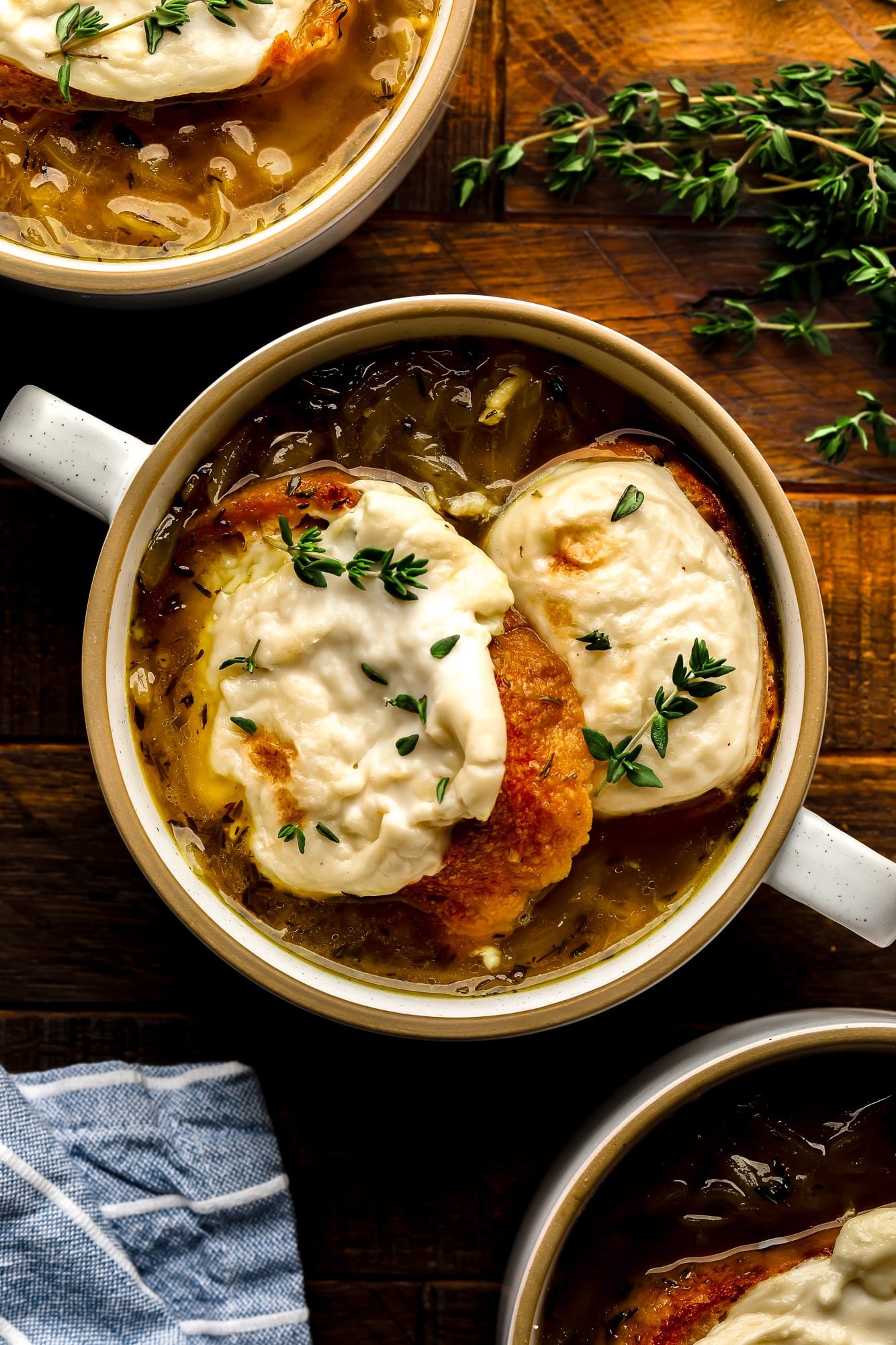 A bowl of vegan French onion soup finished off with toasted vegan cheese bread.