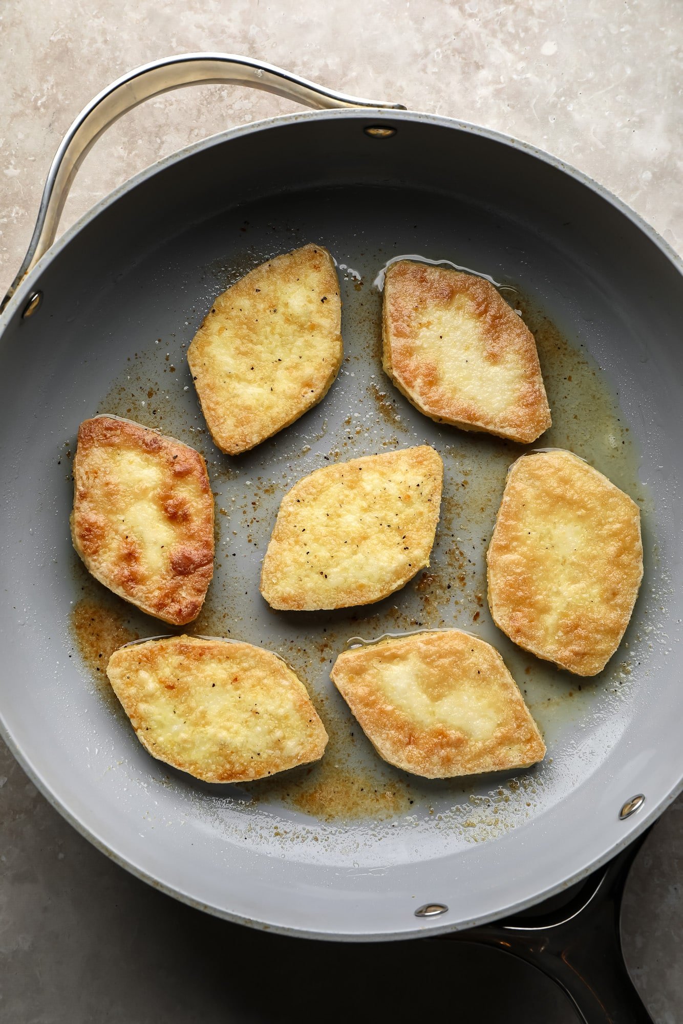 Fry tofu pieces in a large pan.