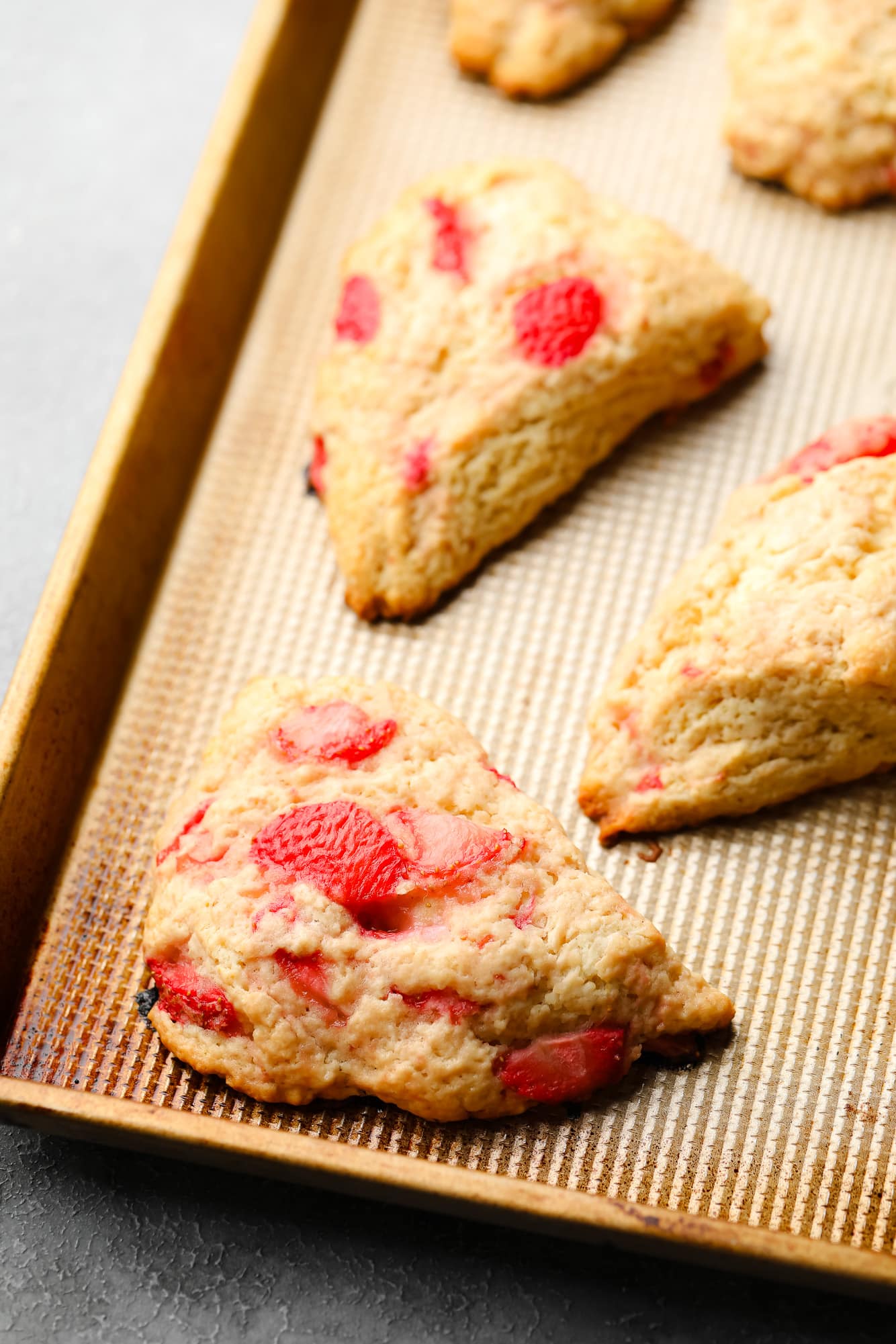 Baked vegan strawberry scones on a baking sheet.