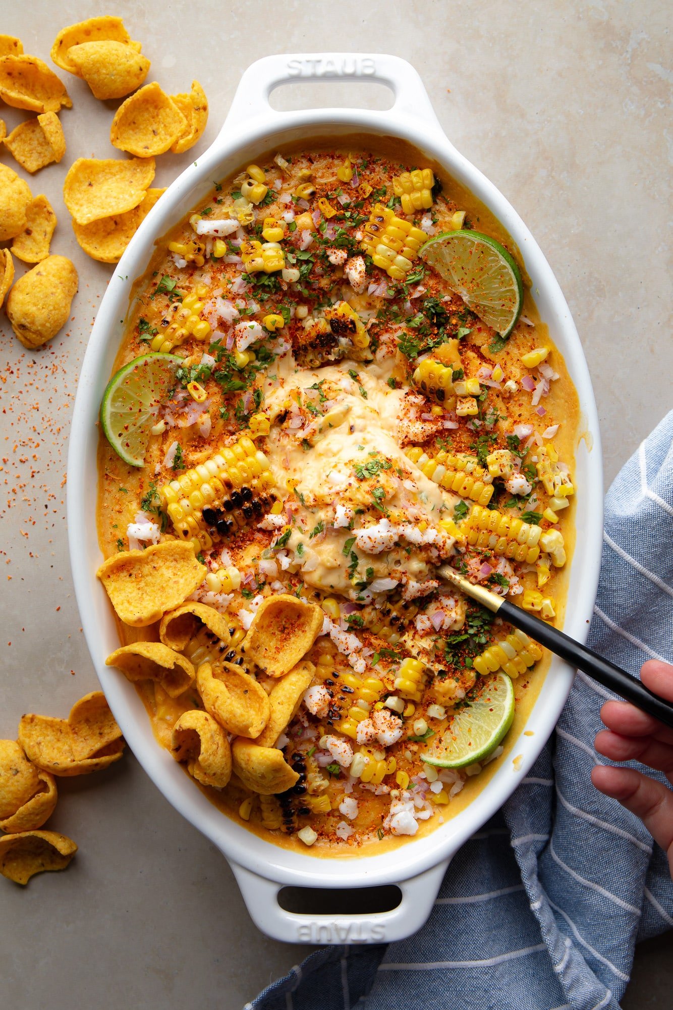 A black spoon in a batch of Mexican vegan corn on a baking dish.